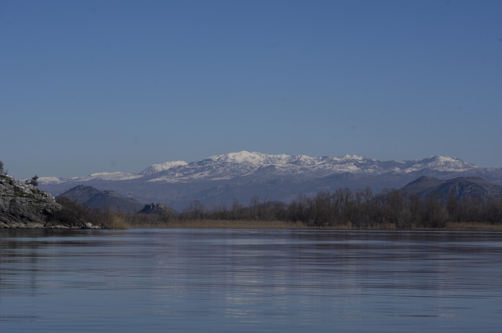 a large body of water with mountains in the background