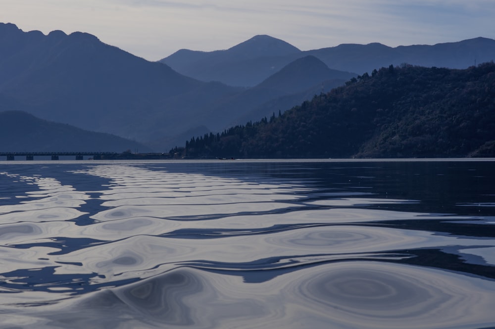 a body of water with mountains in the background