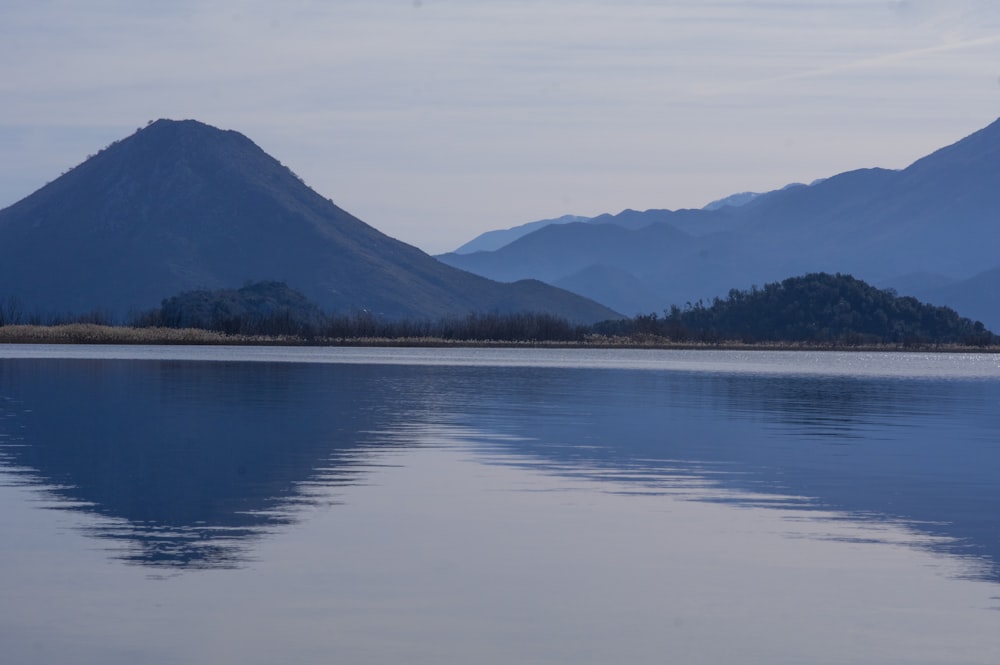 a large body of water with mountains in the background