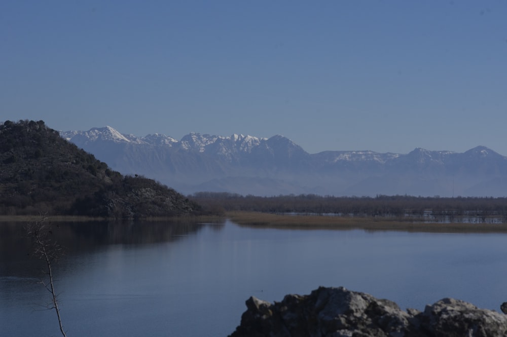 a large body of water with mountains in the background