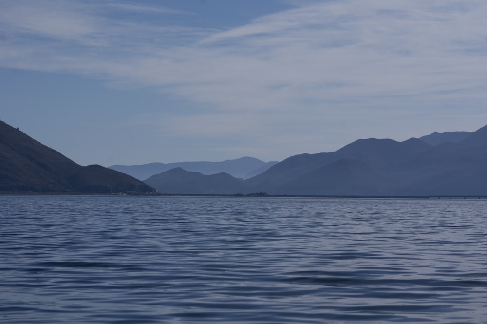 a body of water with mountains in the background