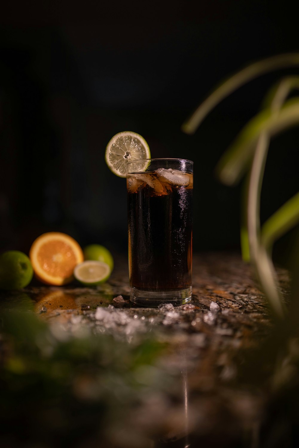 a glass of soda with a slice of lemon on the side