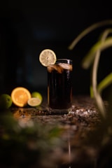 a glass of soda with a slice of lemon on the side