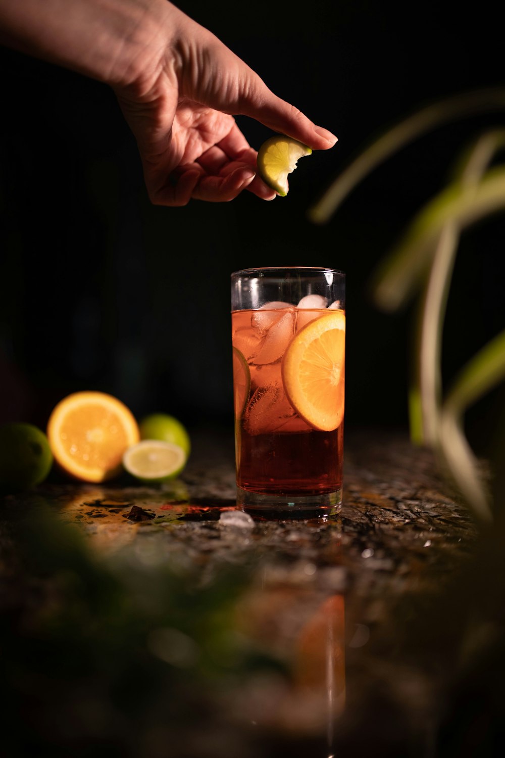 a person is squeezing a lemon into a glass