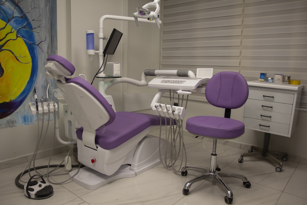 a dentist chair with a purple seat in a room