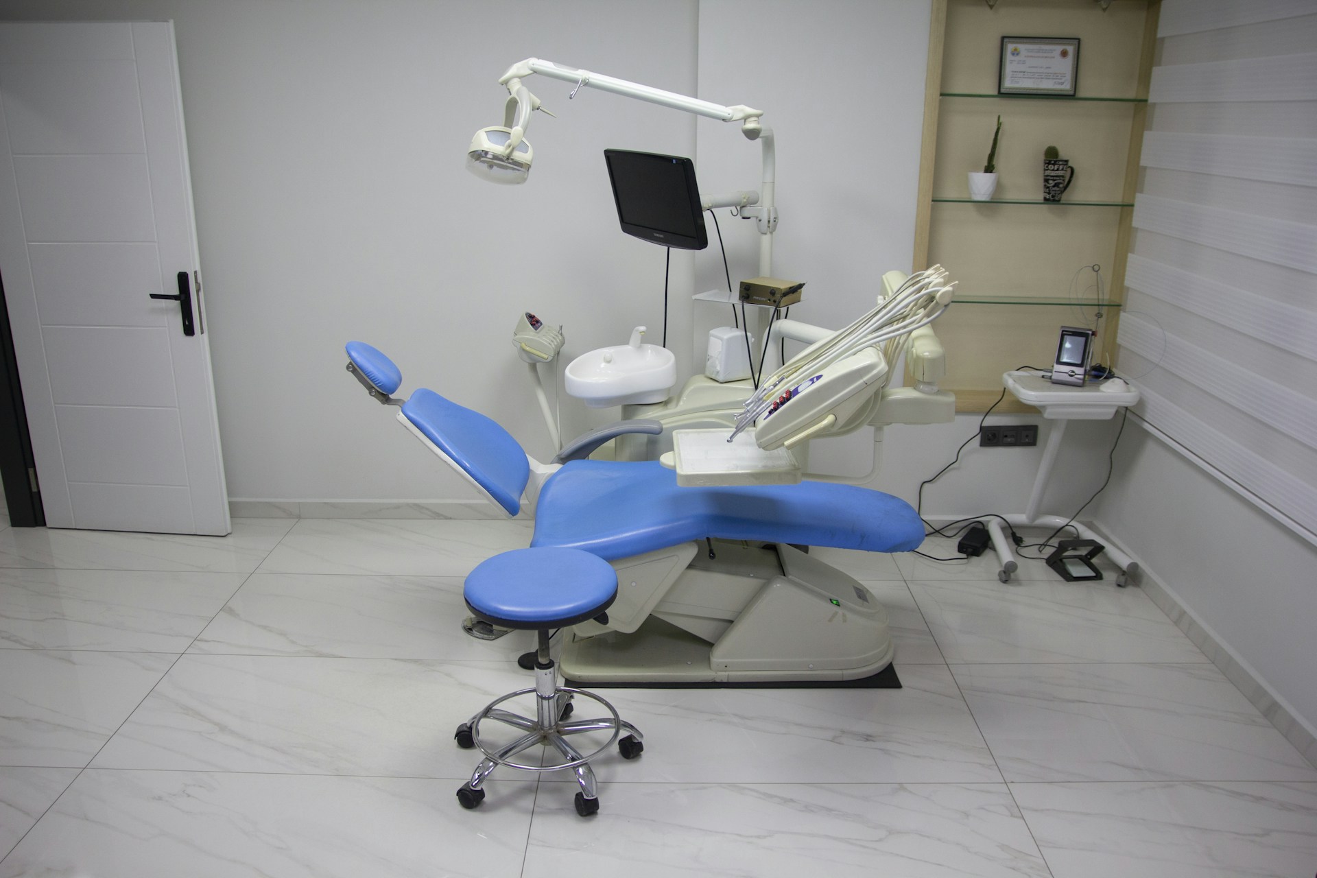 a dentist chair with a blue seat in a room