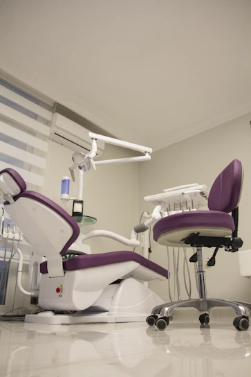 Bright and welcoming dental clinic reception area with modern white and purple decor.