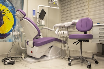 a purple and white dental chair in a room