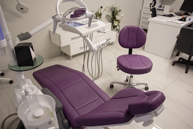 a purple chair sitting in a room next to a desk