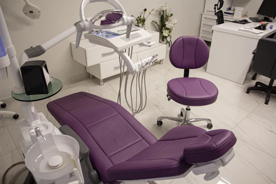 a purple chair sitting in a room next to a desk