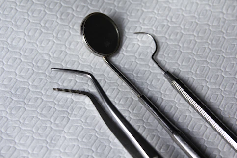 Close-up of a vibrant crimson dental instrument set arranged neatly on a beige surface.