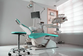 Un consultorio dental con una silla y un monitor.
