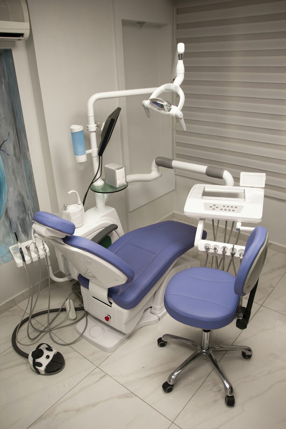 a dental room with a blue chair and dental equipment