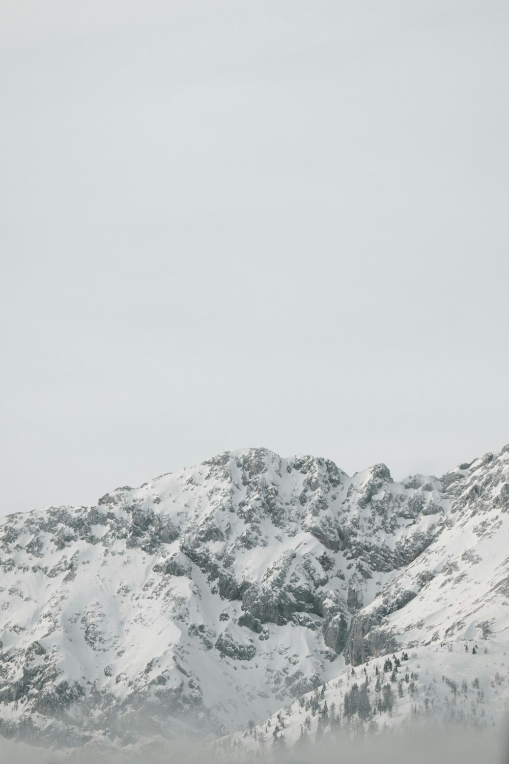 a mountain covered in snow with a sky background