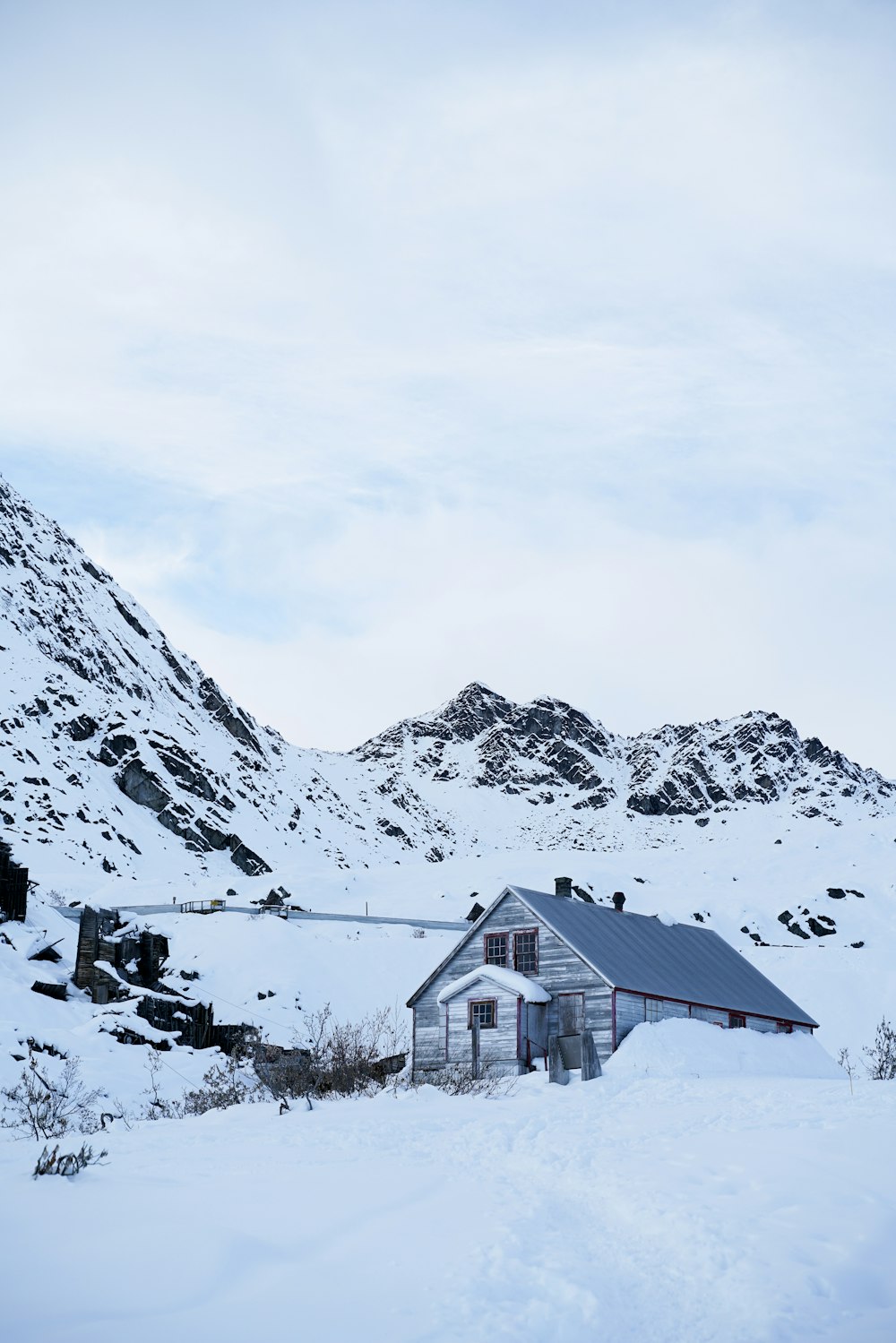 a house in the middle of a snowy mountain