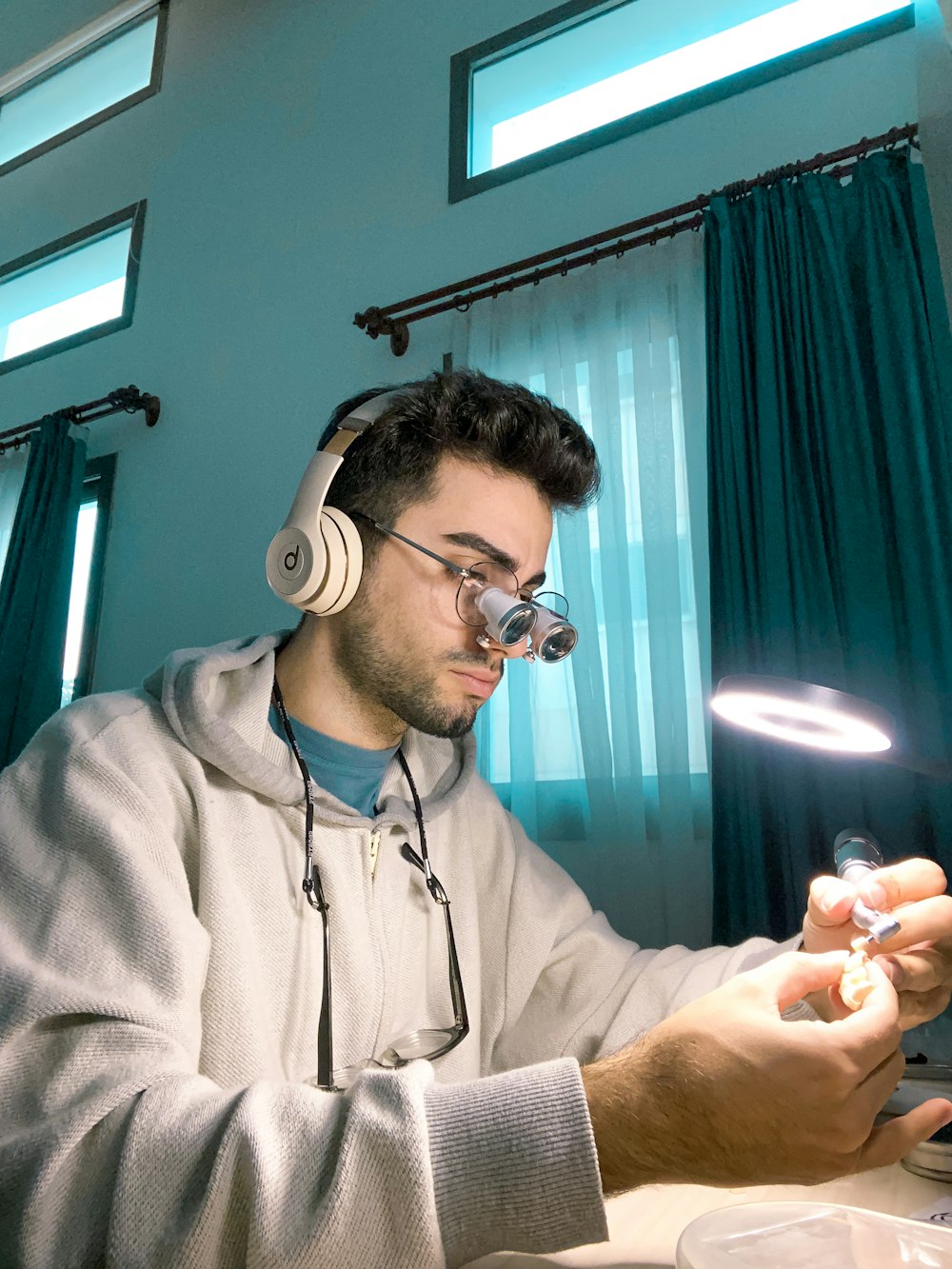 um homem sentado em uma mesa com fones de ouvido ligados