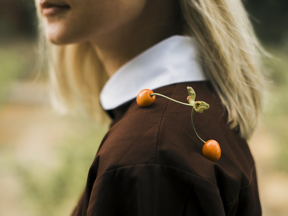 a woman wearing a brown shirt with cherries on it