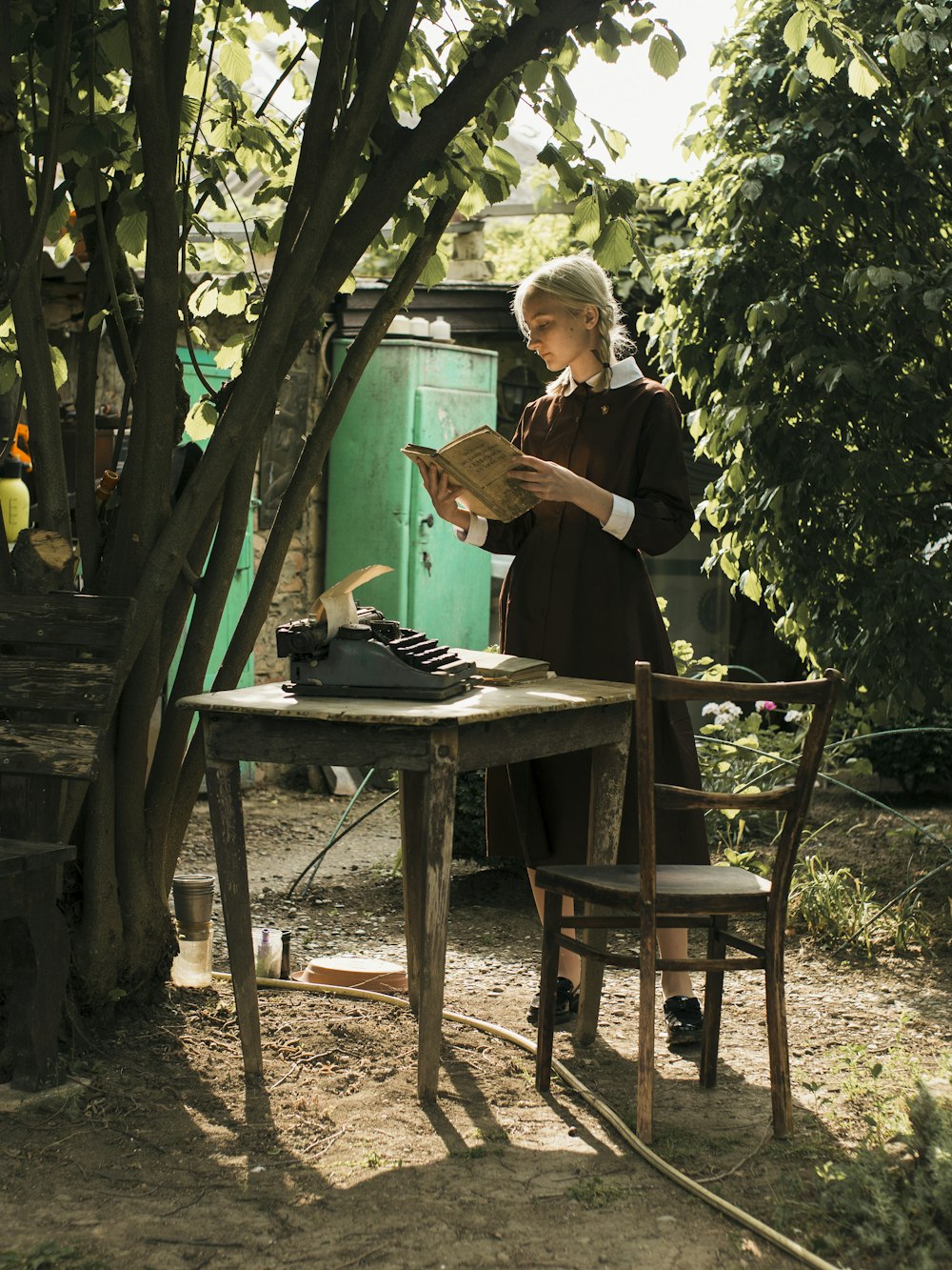 a woman standing at a table with a typewriter