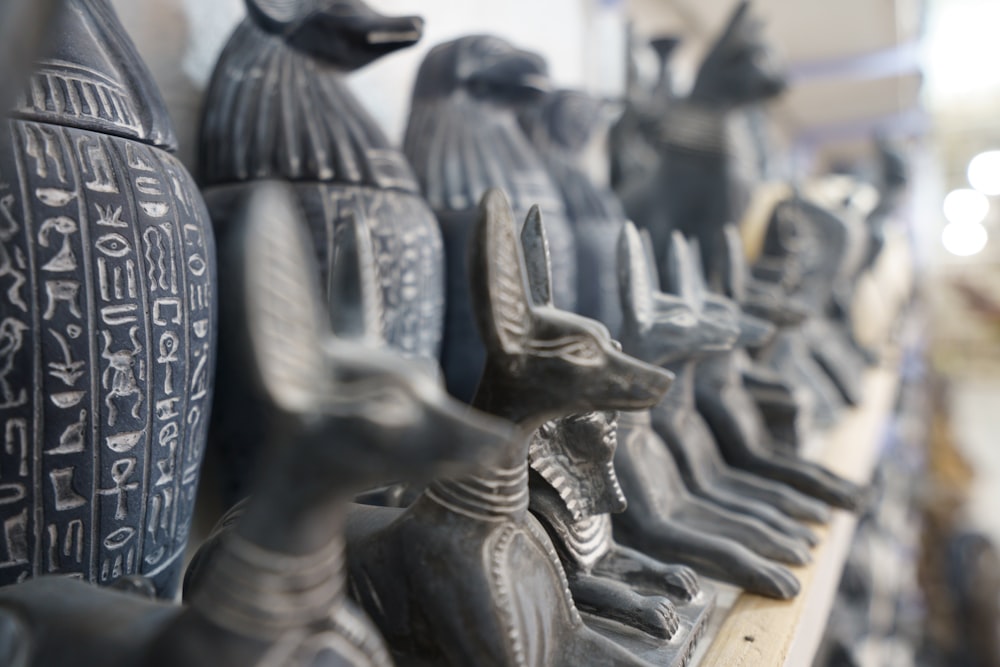 a row of black statues sitting on top of a shelf
