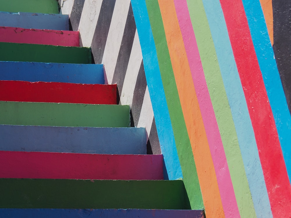 une cage d’escalier multicolore avec un mur rayé