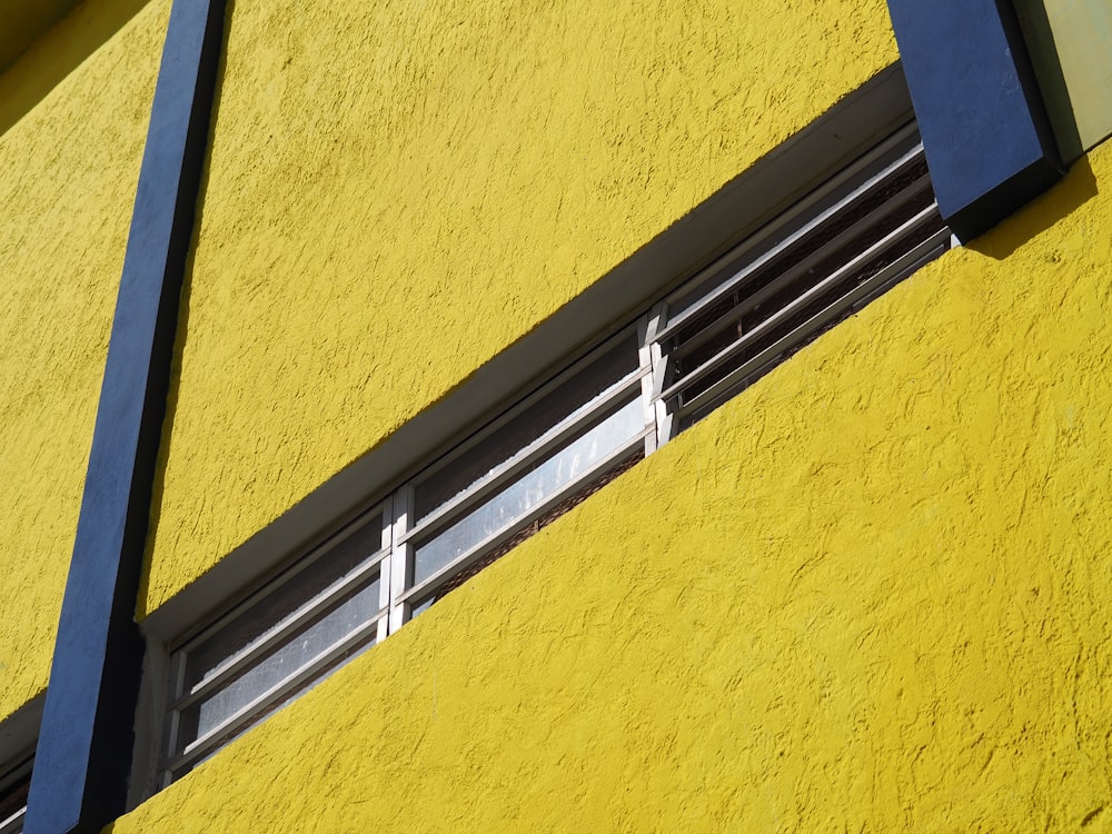 a close up of a window on a yellow building