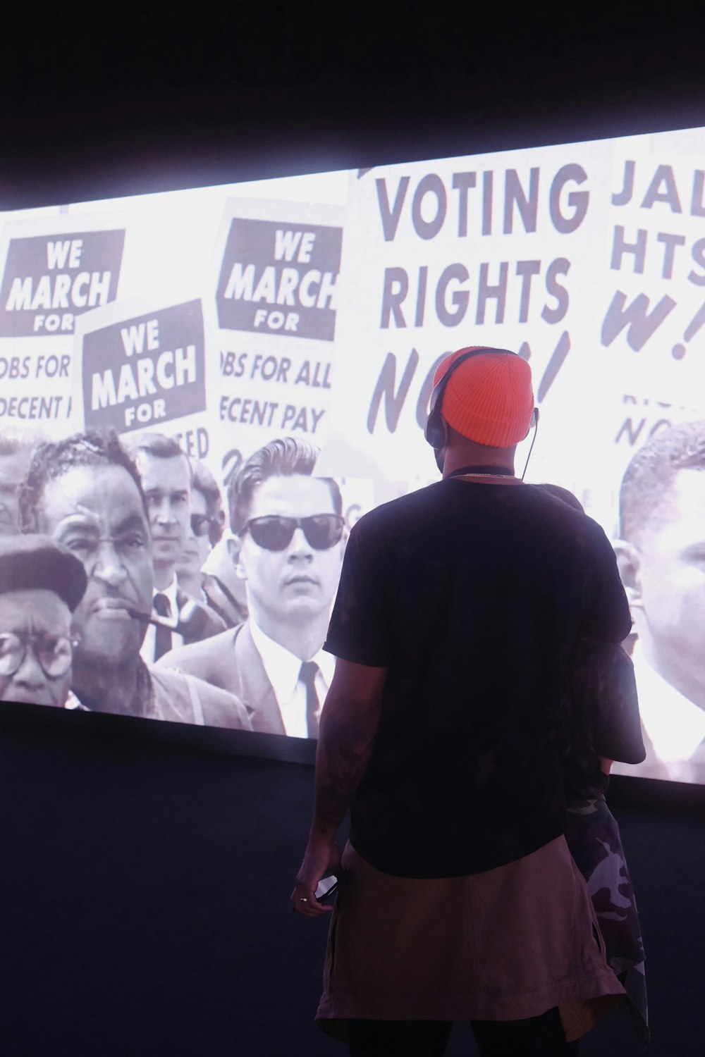 a man standing in front of a large screen