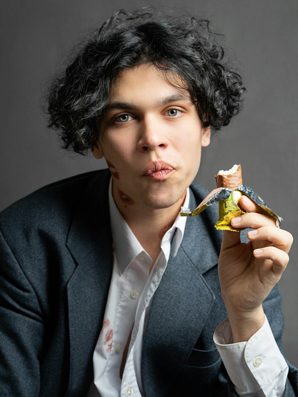 a man in a suit eating a piece of food