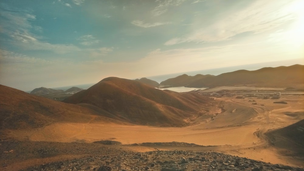 a desert landscape with mountains and a body of water