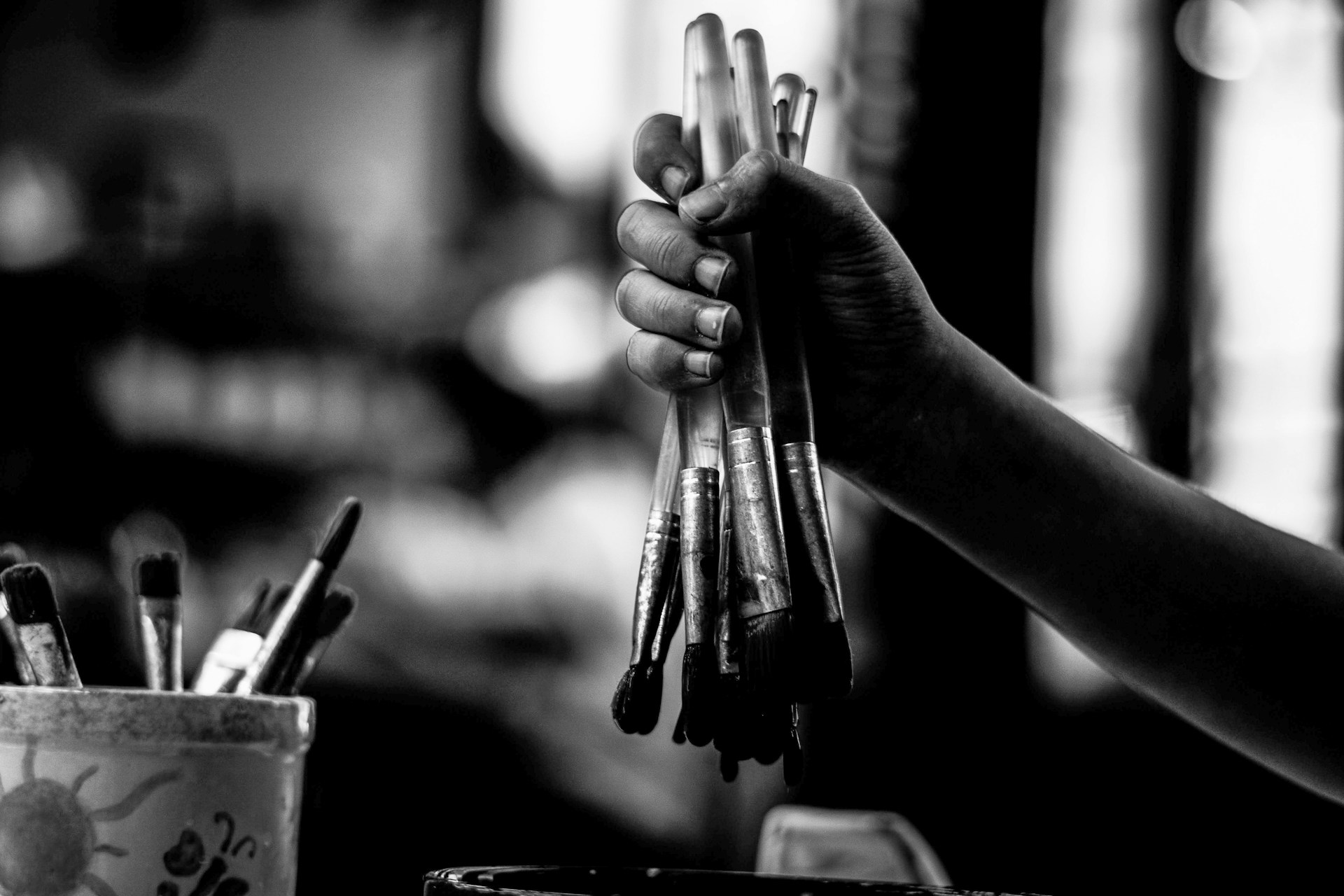 a black and white photo of a person holding a bunch of pens