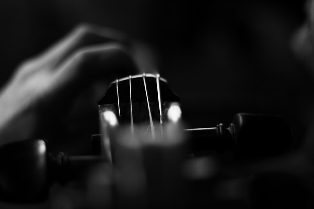 Una foto en blanco y negro de una persona tocando una guitarra