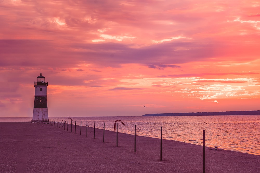 a light house sitting on top of a beach next to the ocean