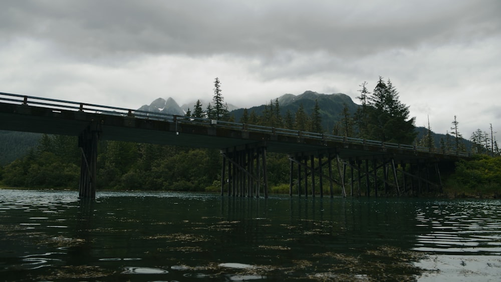 a bridge over a body of water with mountains in the background