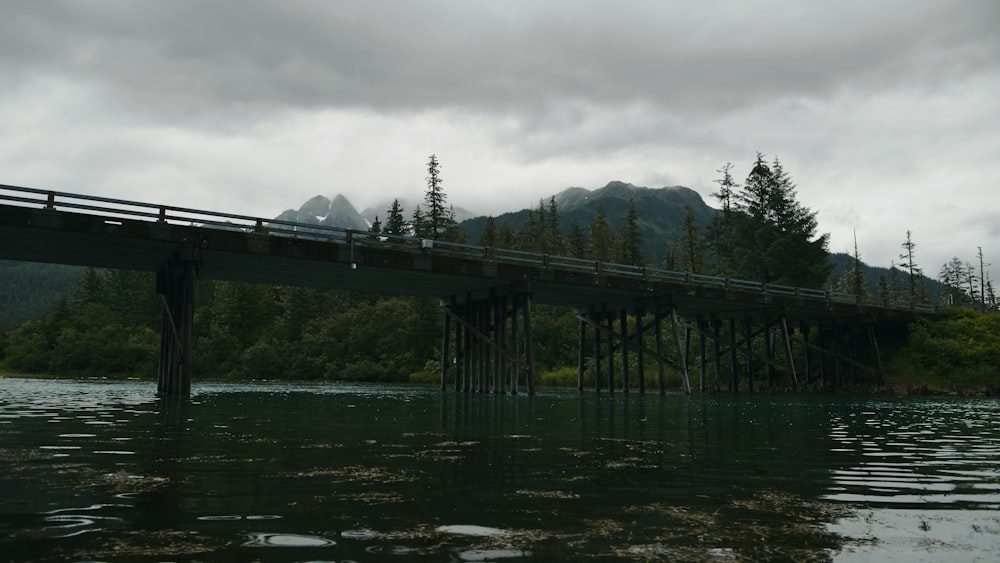 Un puente sobre un cuerpo de agua con montañas al fondo