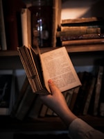 A user holding the book with a smile in a study environment.