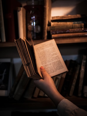 A user holding the book with a smile in a study environment.