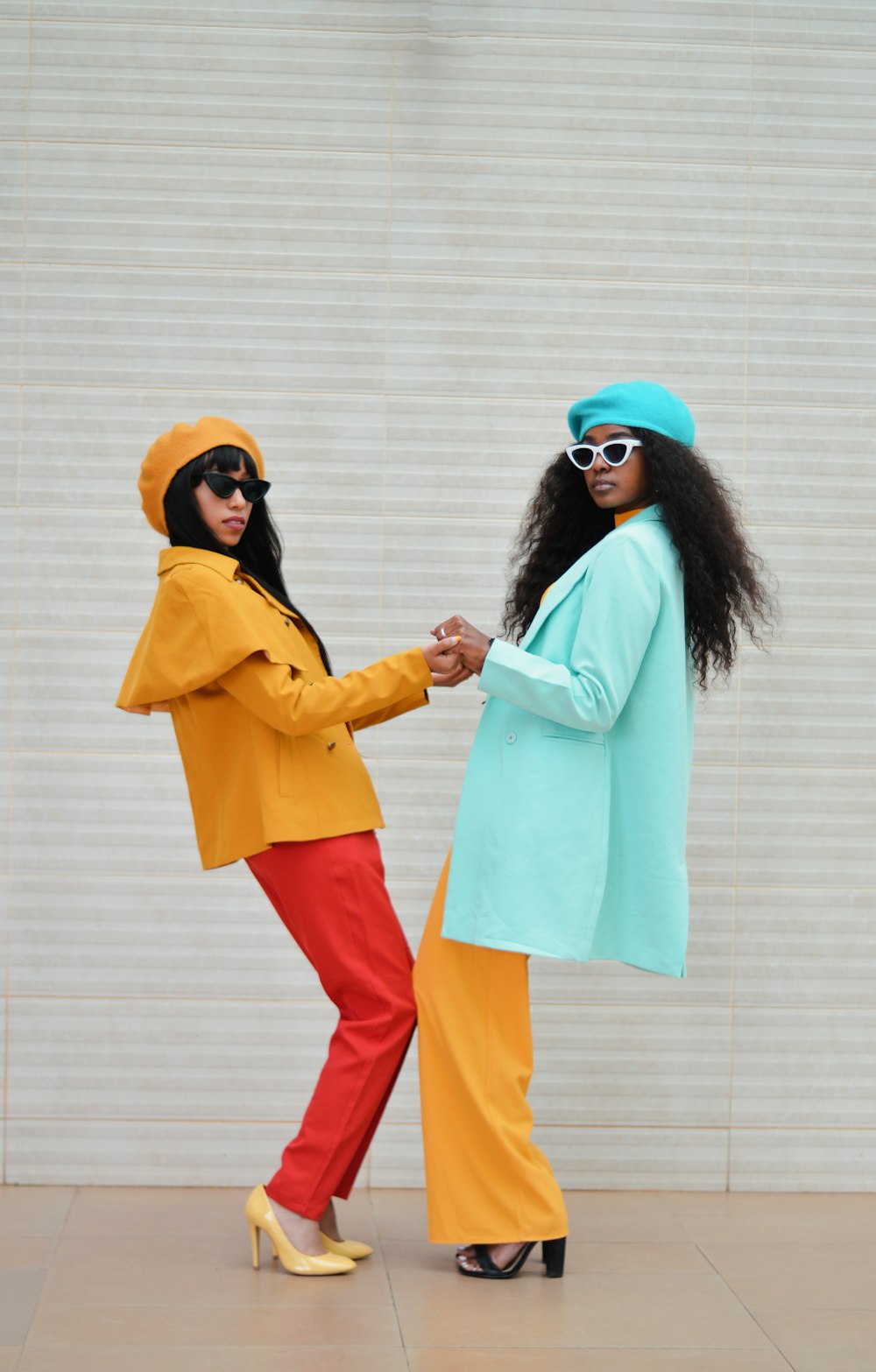 two women dressed in colorful clothing standing next to each other