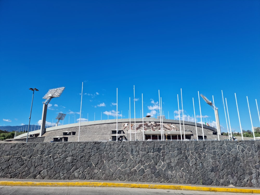 a stone wall with flags and a building in the background