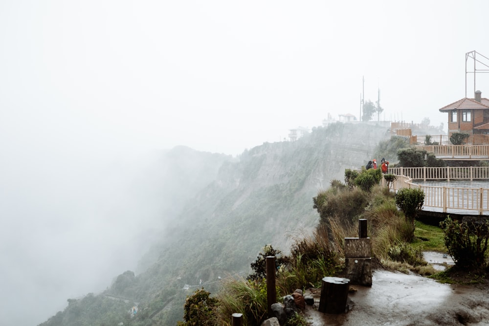 a foggy mountain with a house on top of it