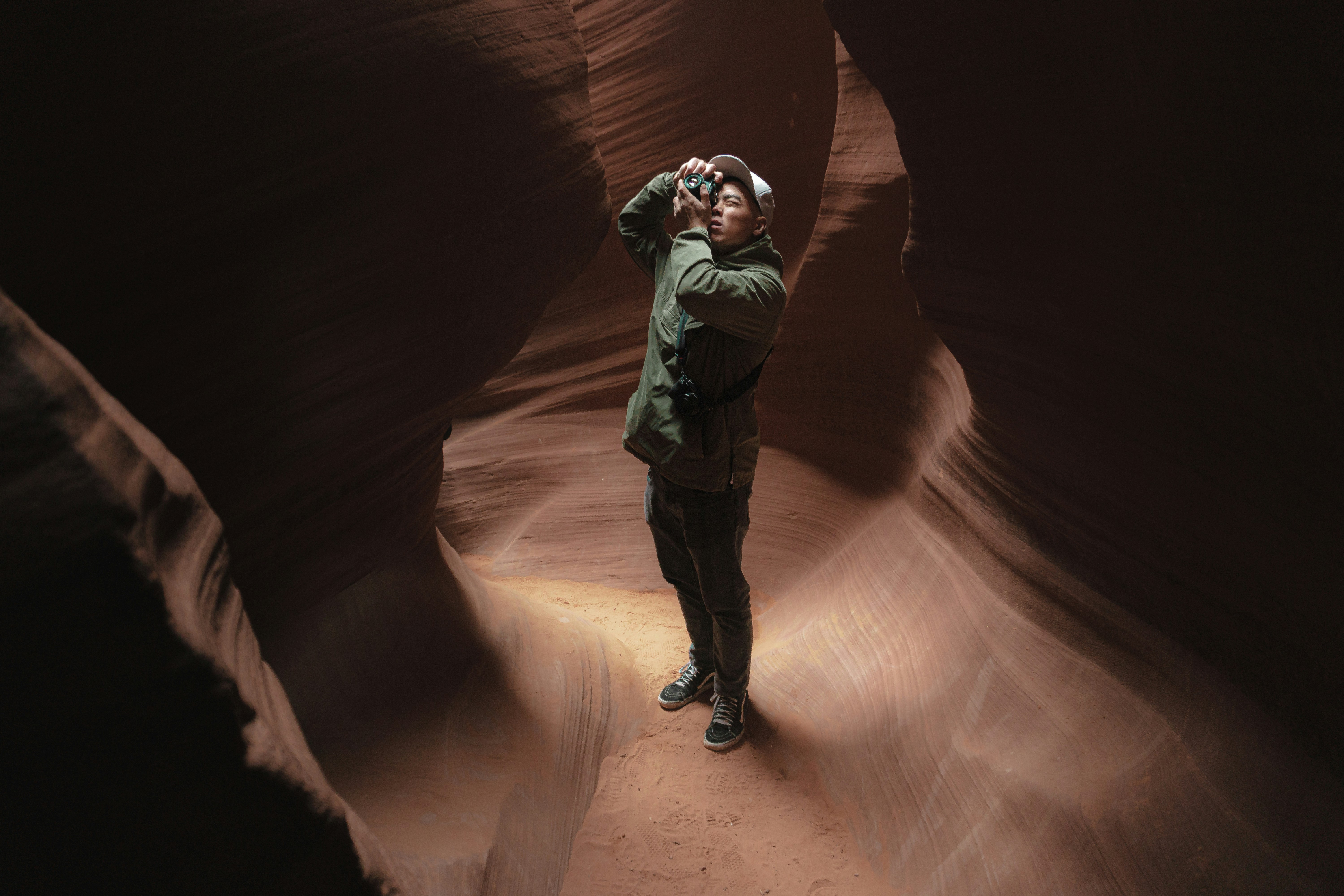a man taking a picture of himself in a canyon, Man taking photo in antelope canyon