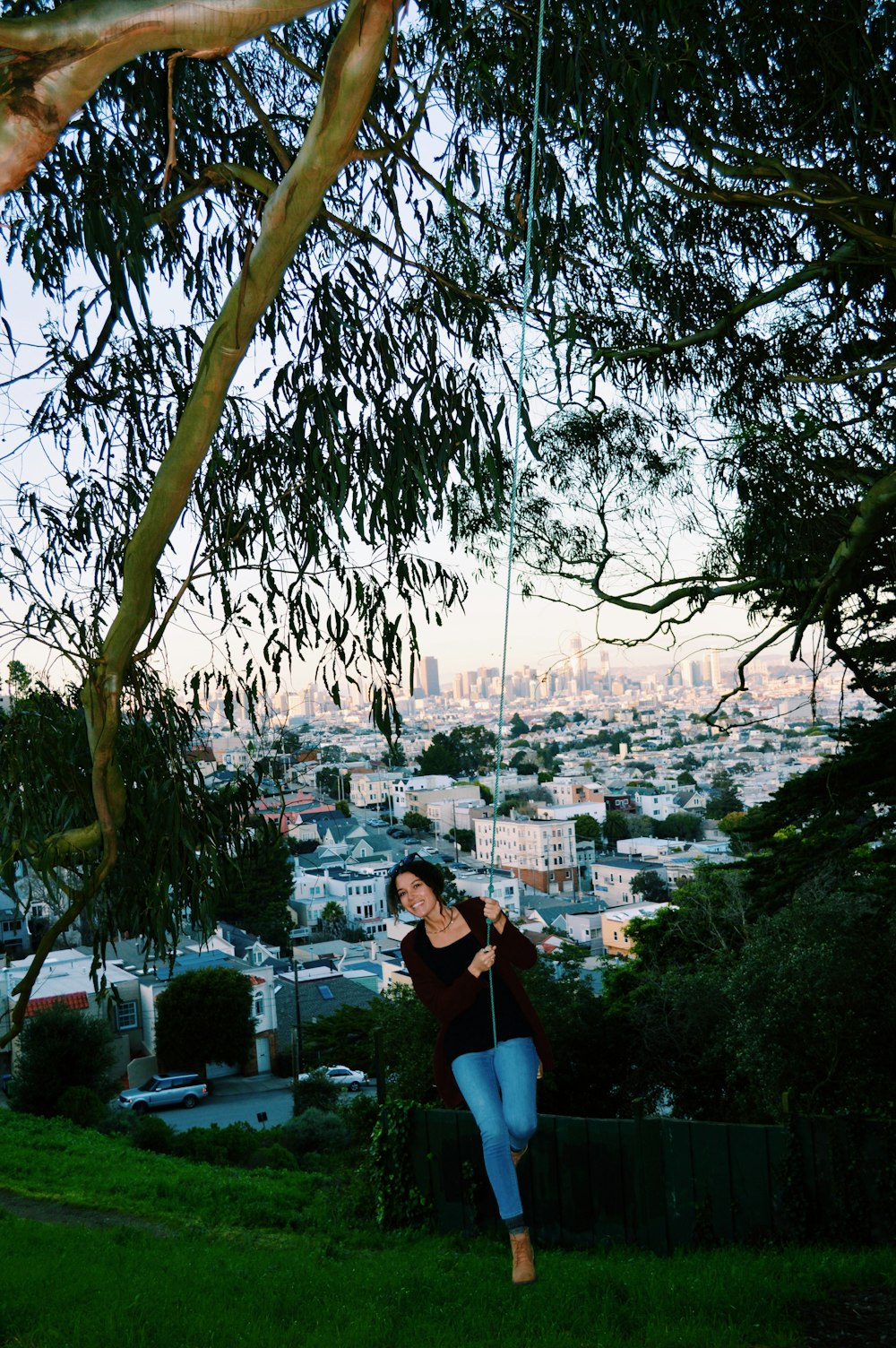 a woman standing on a hill with a city in the background