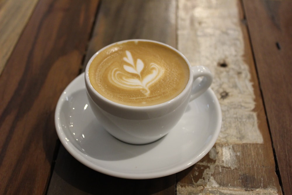 a cup of coffee on a saucer on a wooden table