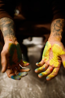 a person with their hands covered in paint