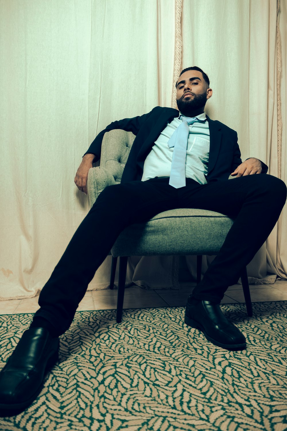 a man in a suit and tie sitting on a chair