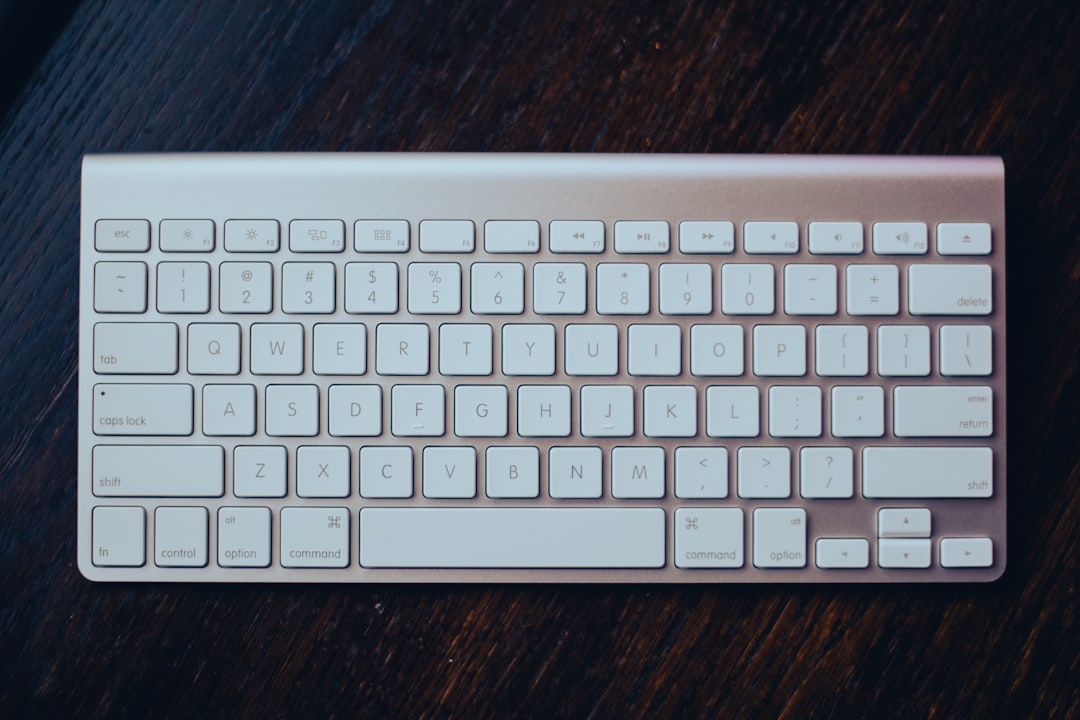 a white keyboard sitting on top of a wooden table, iMac Keyboard