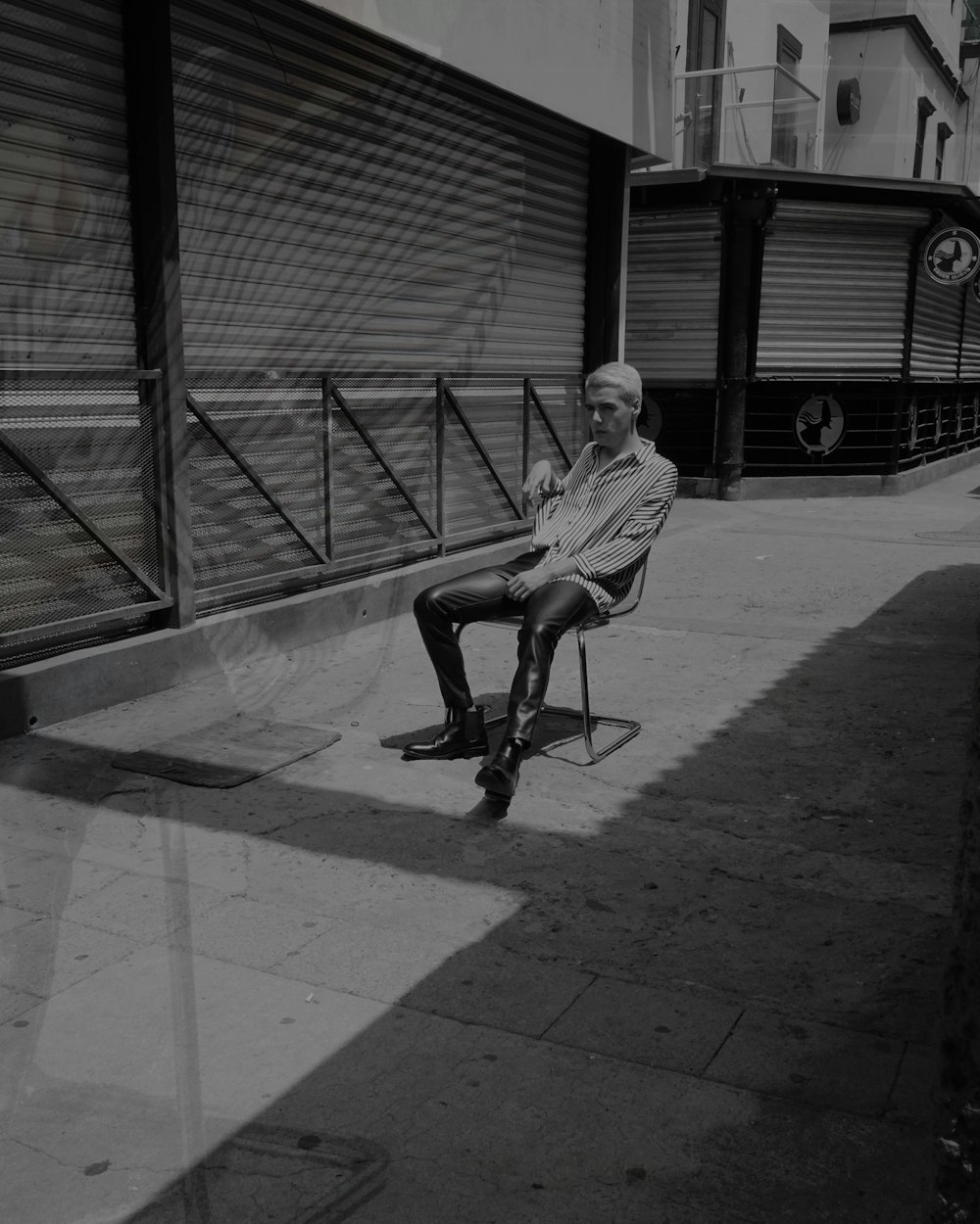 a man sitting on a skateboard on a sidewalk