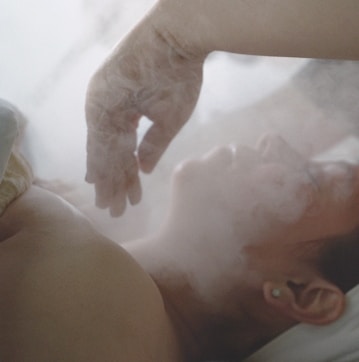 a woman laying in bed with steam coming out of her stomach