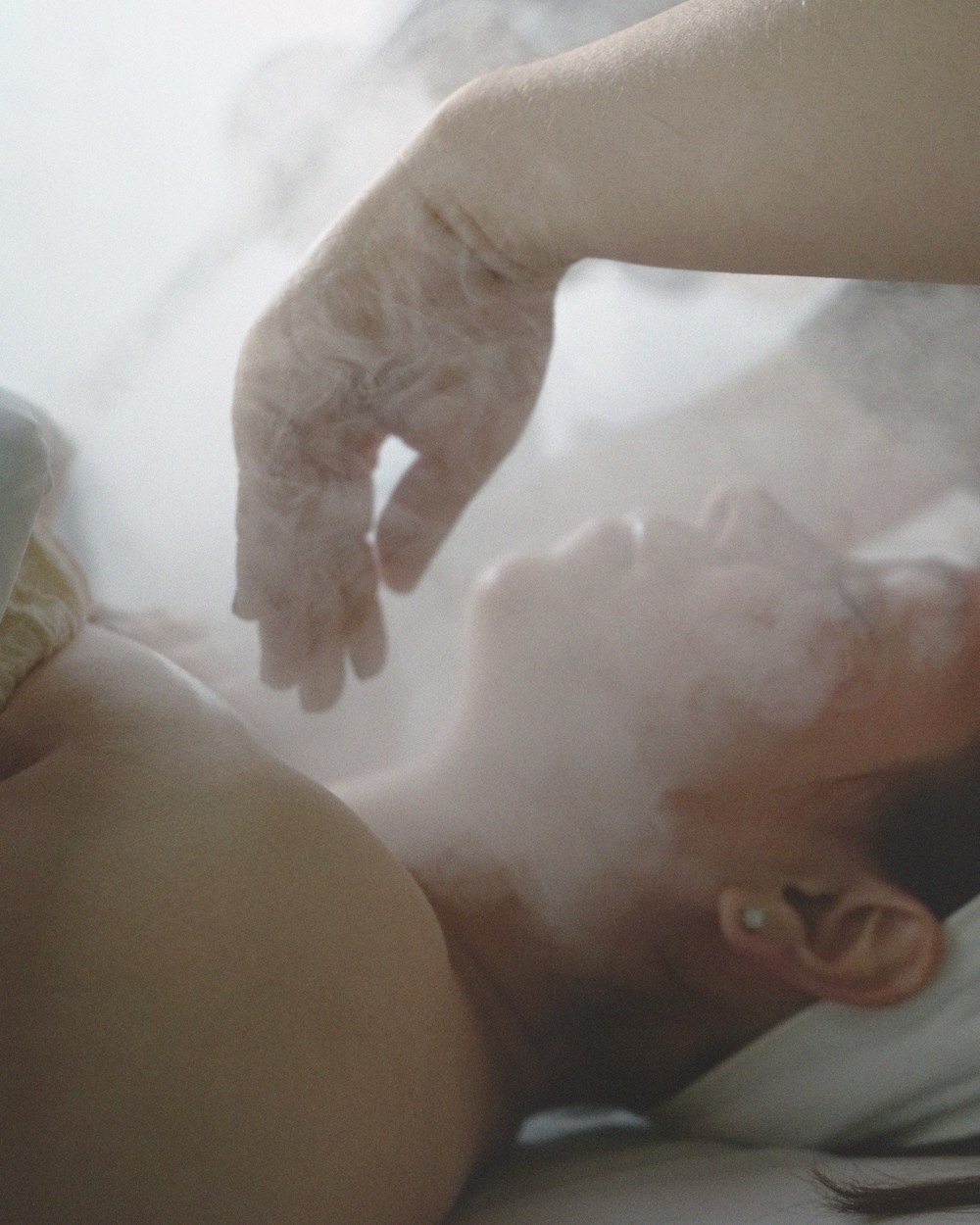 a woman laying in bed with steam coming out of her stomach