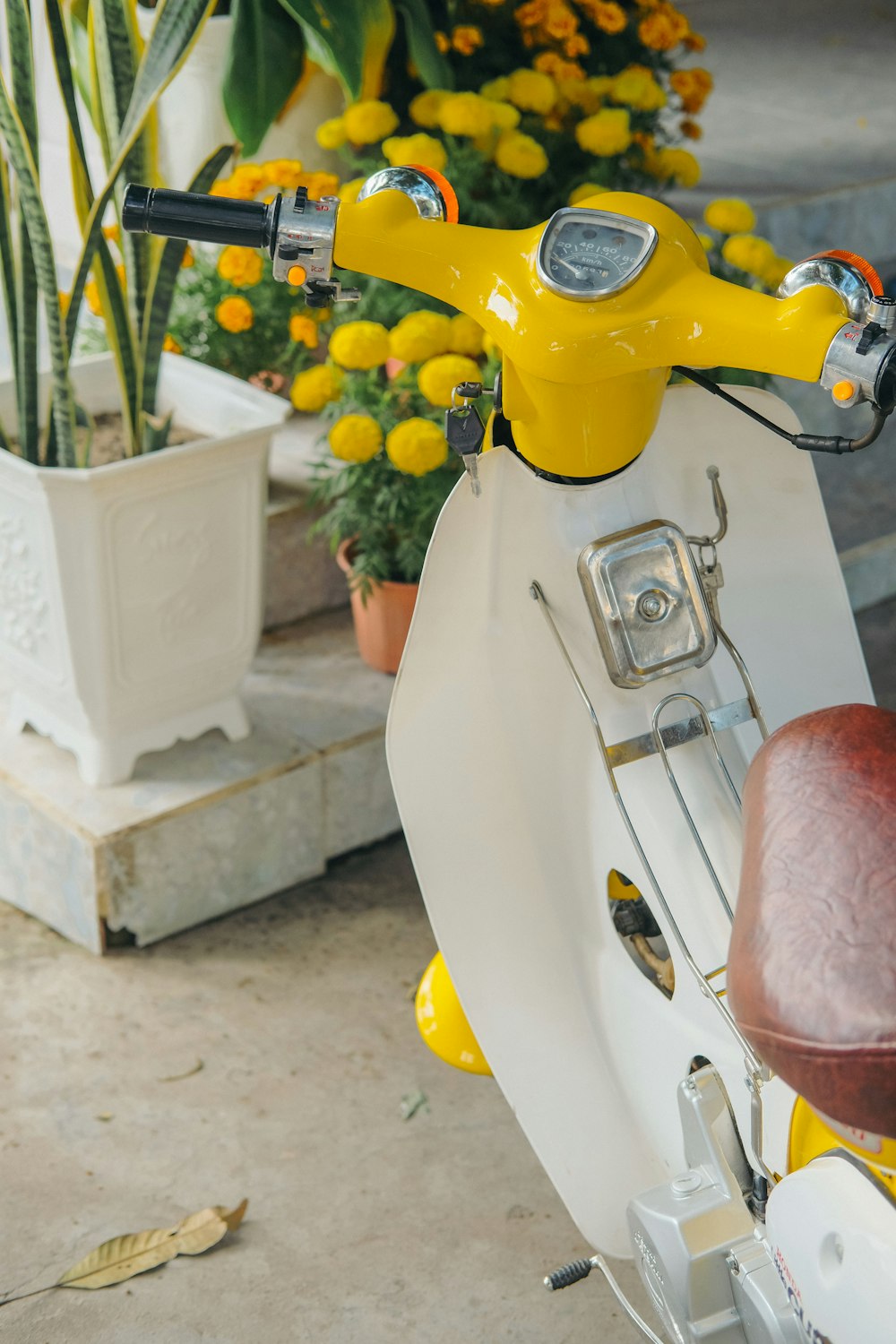a yellow and white scooter parked in front of a house