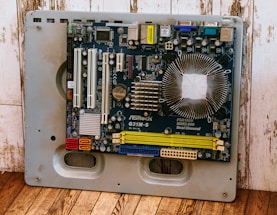 a computer motherboard sitting on top of a wooden floor