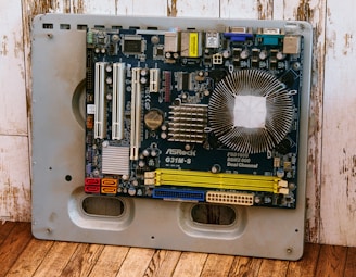 a computer motherboard sitting on top of a wooden floor